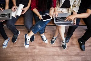 A picture of students sat on a bench working together.