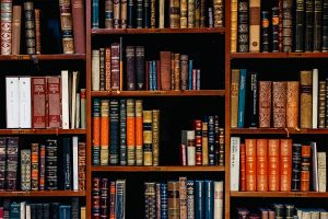 A book case with many different books in it.